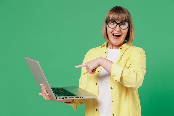Excited woman holding a laptop