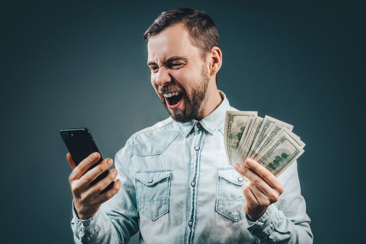 Excited man with big savings on his phone or phone plan